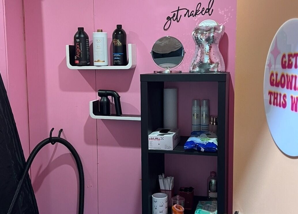 Polished By Court's pink beauty corner in Auckland, NZ, featuring tanning supplies and glow signs.