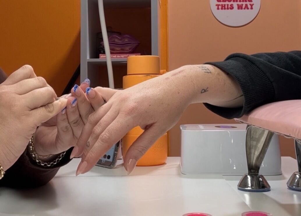 Nail artist at Polished By Court in Auckland, NZ crafting intricate nail designs on a client.