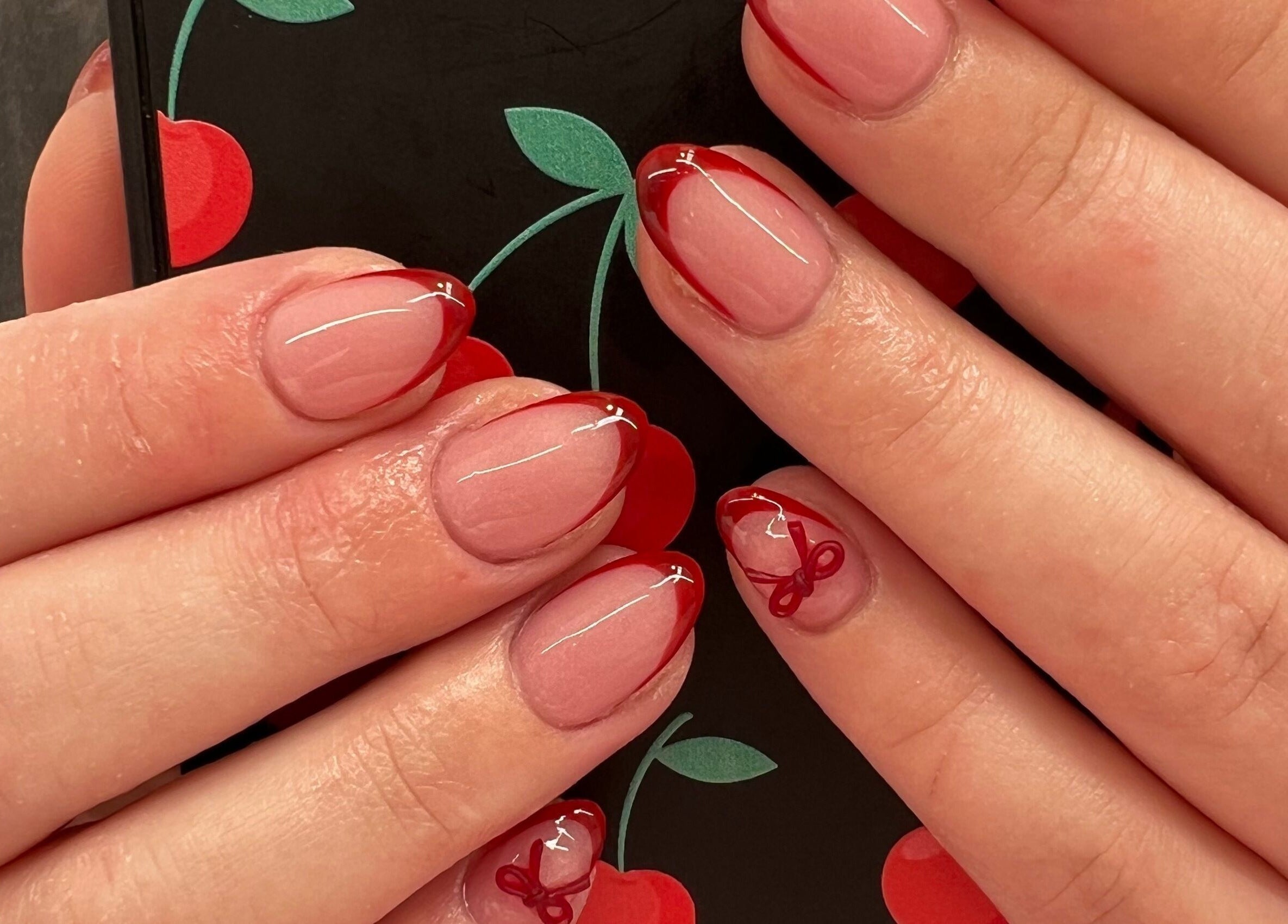 Elegant cherry-themed manicure at Polished By Court, Auckland, Auckland, NZ featuring red tips and designs.
