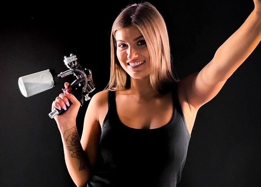 Spray artist smiling at Sol Sunless Tanning - Dallas Mockingbird, Dallas, Texas, US with tanning equipment.