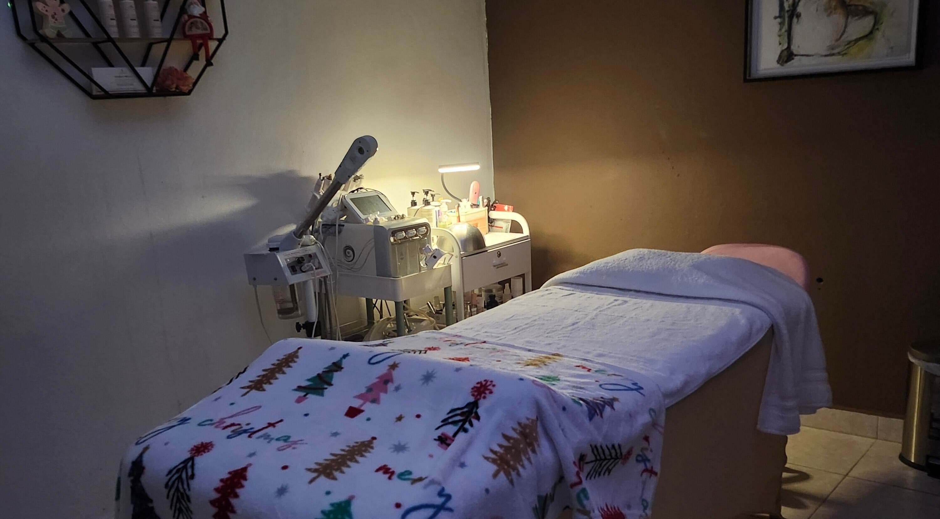 Sala de tratamiento en Skincare by AB, San Juan, San Juan, PR, con camilla decorada y equipo estético.