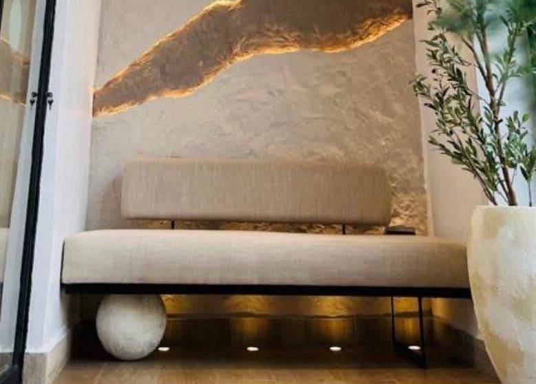 Cozy seating area at The Triplets Studio, Lagos, Lagos, NG with a soft bench and decorative plant.