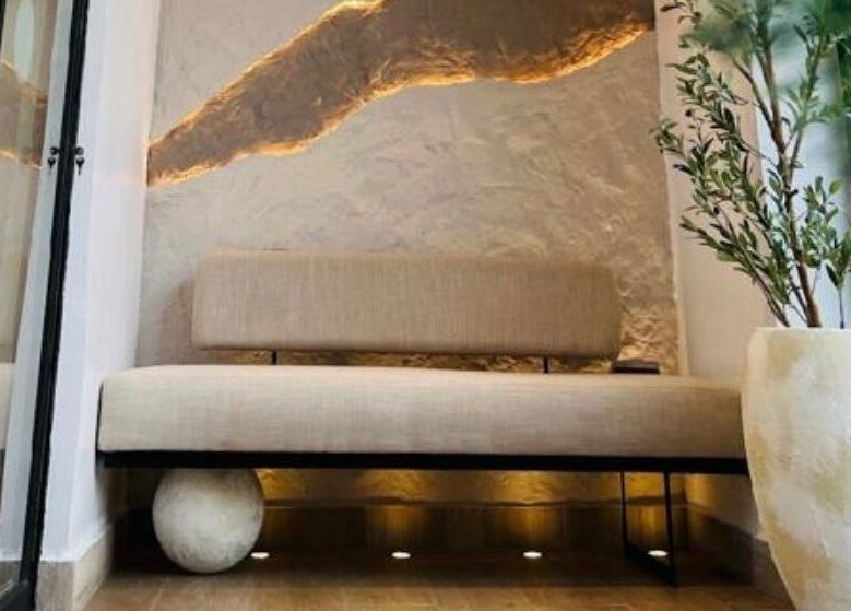 Cozy seating area at The Triplets Studio, Lagos, Lagos, NG with a soft bench and decorative plant.