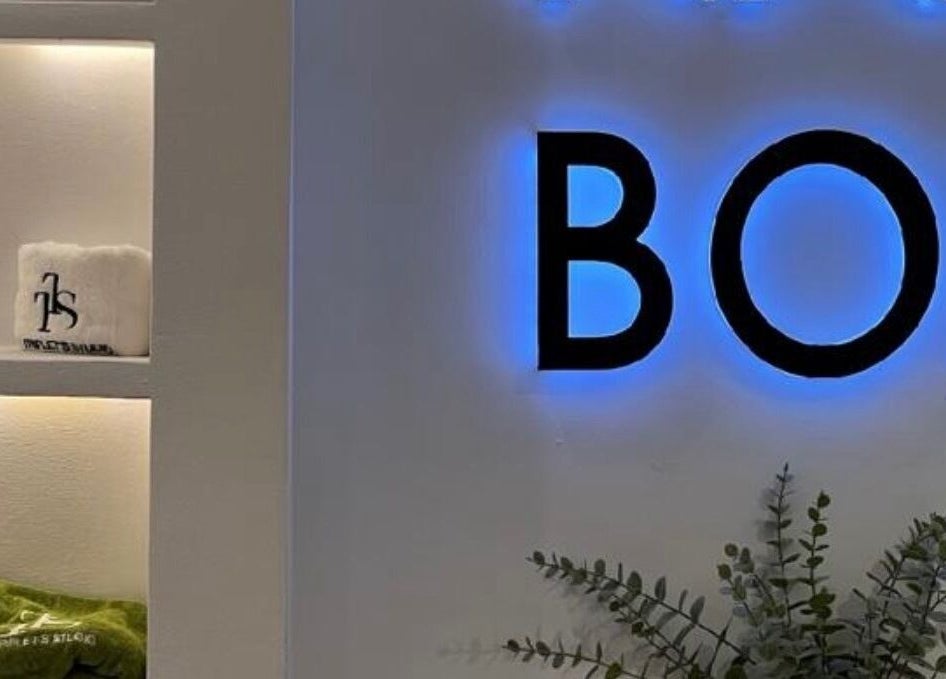 Illuminated signage at The Triplets Studio in Lagos, Lagos, NG showcasing serene decor and lush greenery.