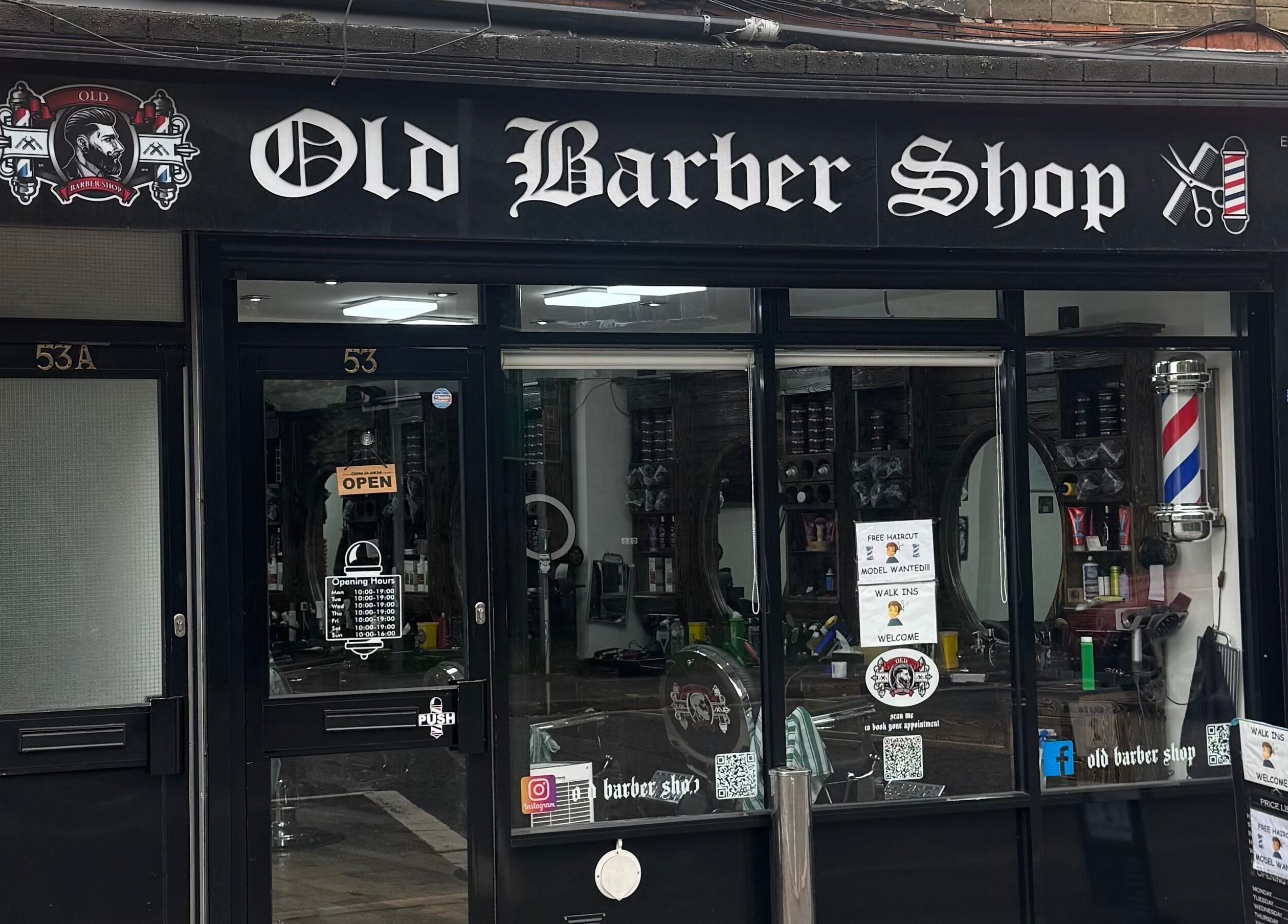 Front view of Old Barber Shop in Northampton, England, GB, showcasing traditional barber pole and inviting decor.