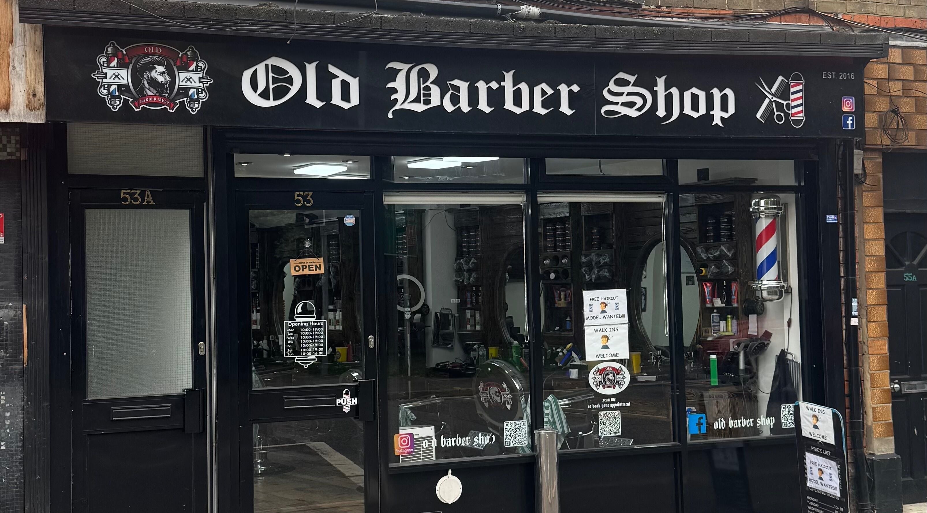 Front view of Old Barber Shop in Northampton, England, GB, showcasing traditional barber pole and inviting decor.