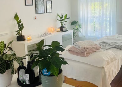 Tranquil treatment room at Logan Joy ~ Holistic Skin, Limerick, County Limerick, IE, with lush plants and cozy linens.