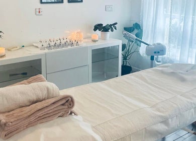 Relaxing spa room at Logan Joy ~ Holistic Skin in Limerick, County Limerick, IE, featuring a massage table and candles.