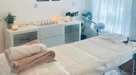 Relaxing spa room at Logan Joy ~ Holistic Skin in Limerick, County Limerick, IE, featuring a massage table and candles.