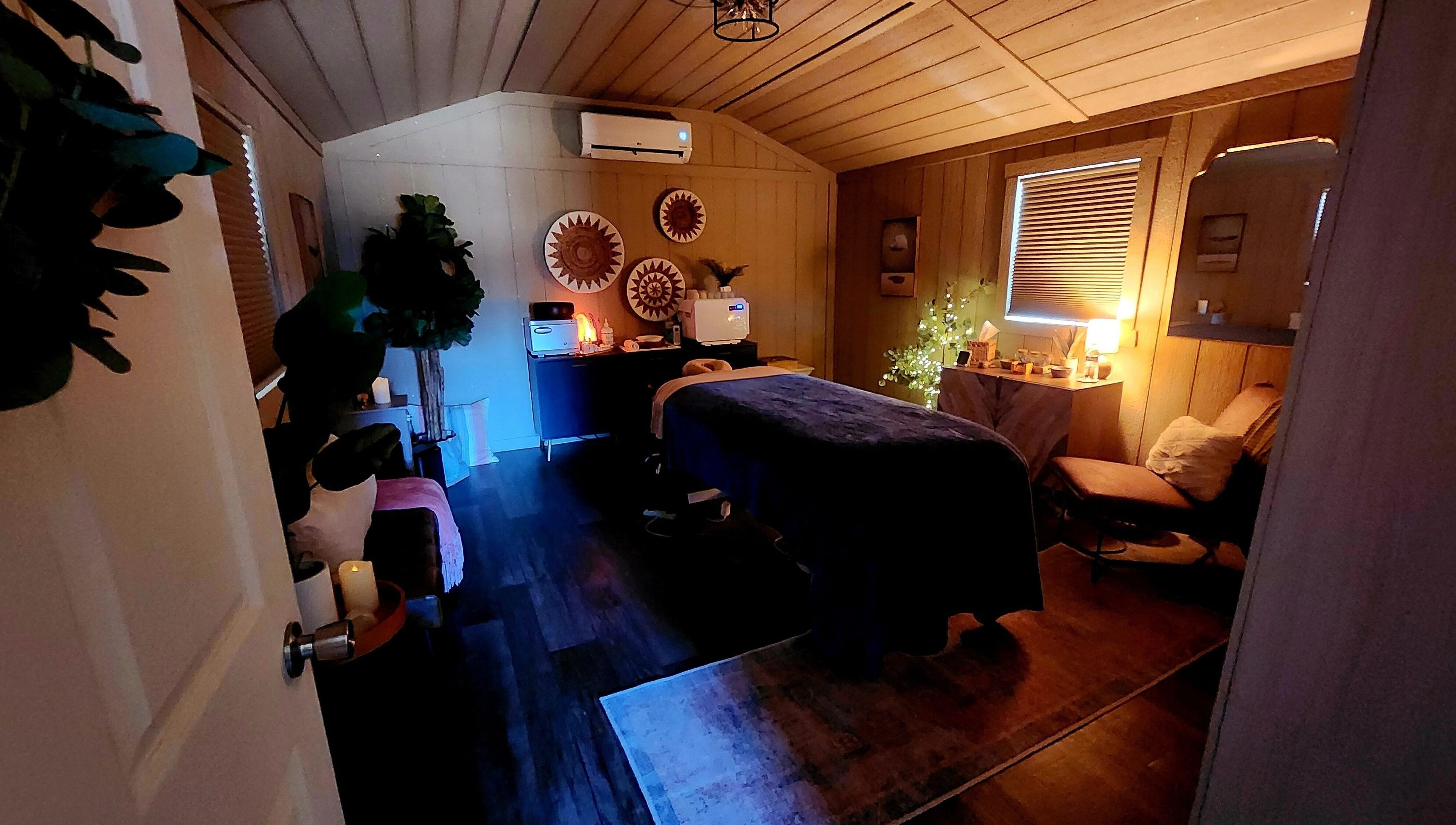 Cozy spa room at CFM, Clayton, North Carolina, US, featuring massage table and ambient lighting.