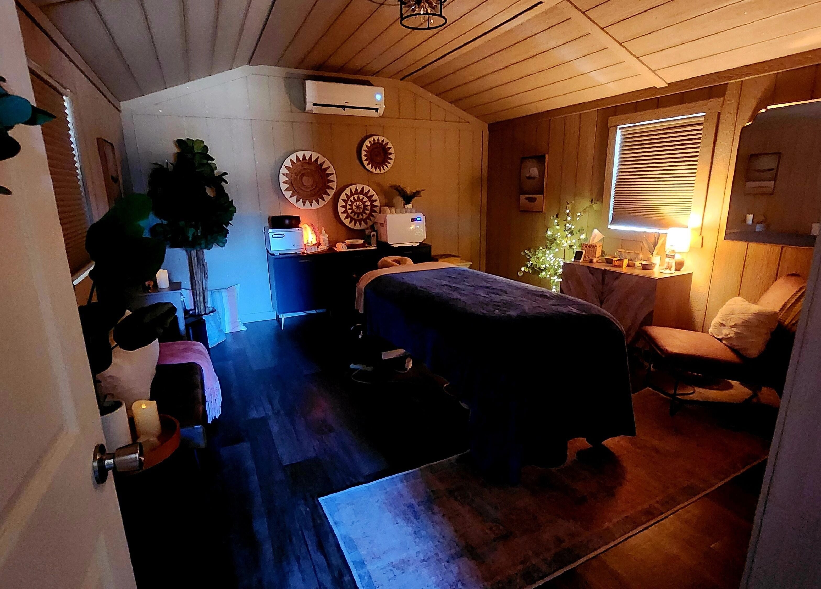 Cozy spa room at CFM, Clayton, North Carolina, US, featuring massage table and ambient lighting.