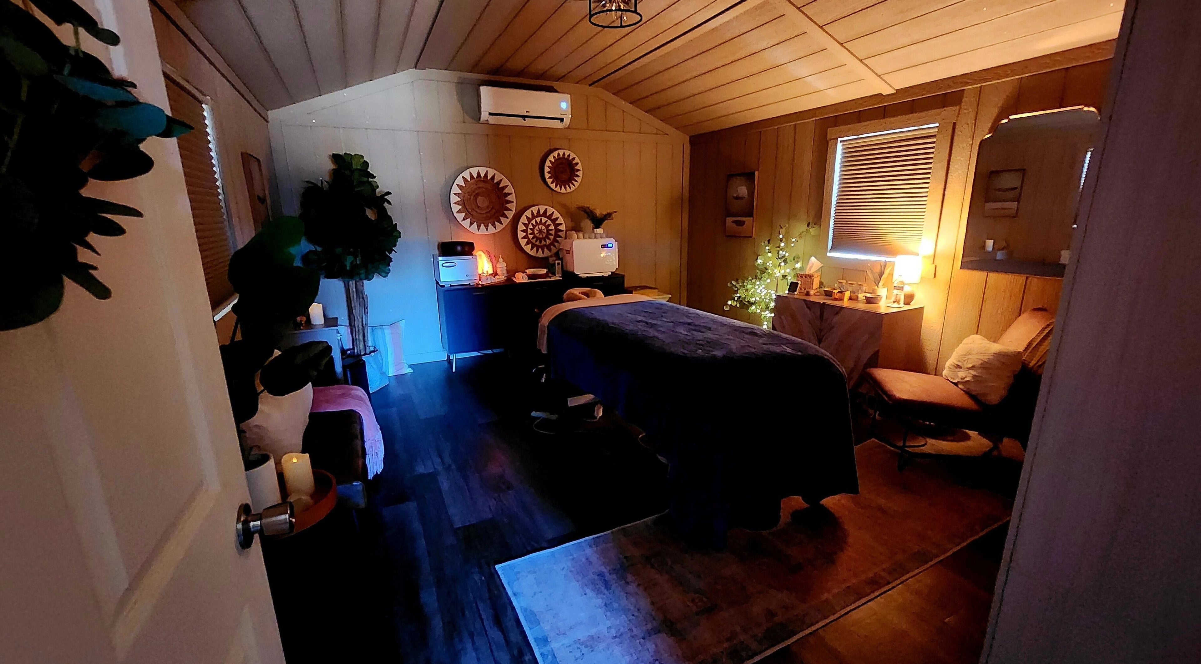 Cozy spa room at CFM, Clayton, North Carolina, US, featuring massage table and ambient lighting.