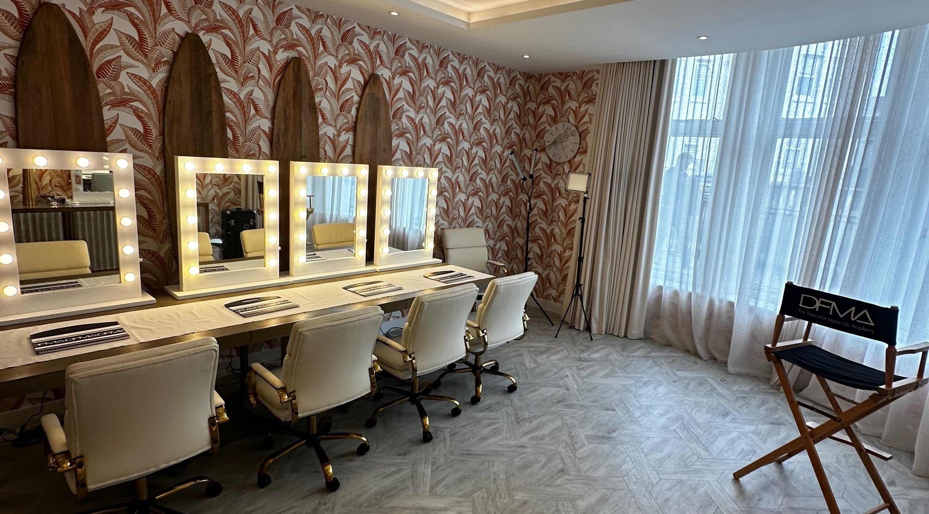 Elegant makeup station at Dfma Make Up & Hair Bar, Poole, England, GB with artist chairs and mirrors.