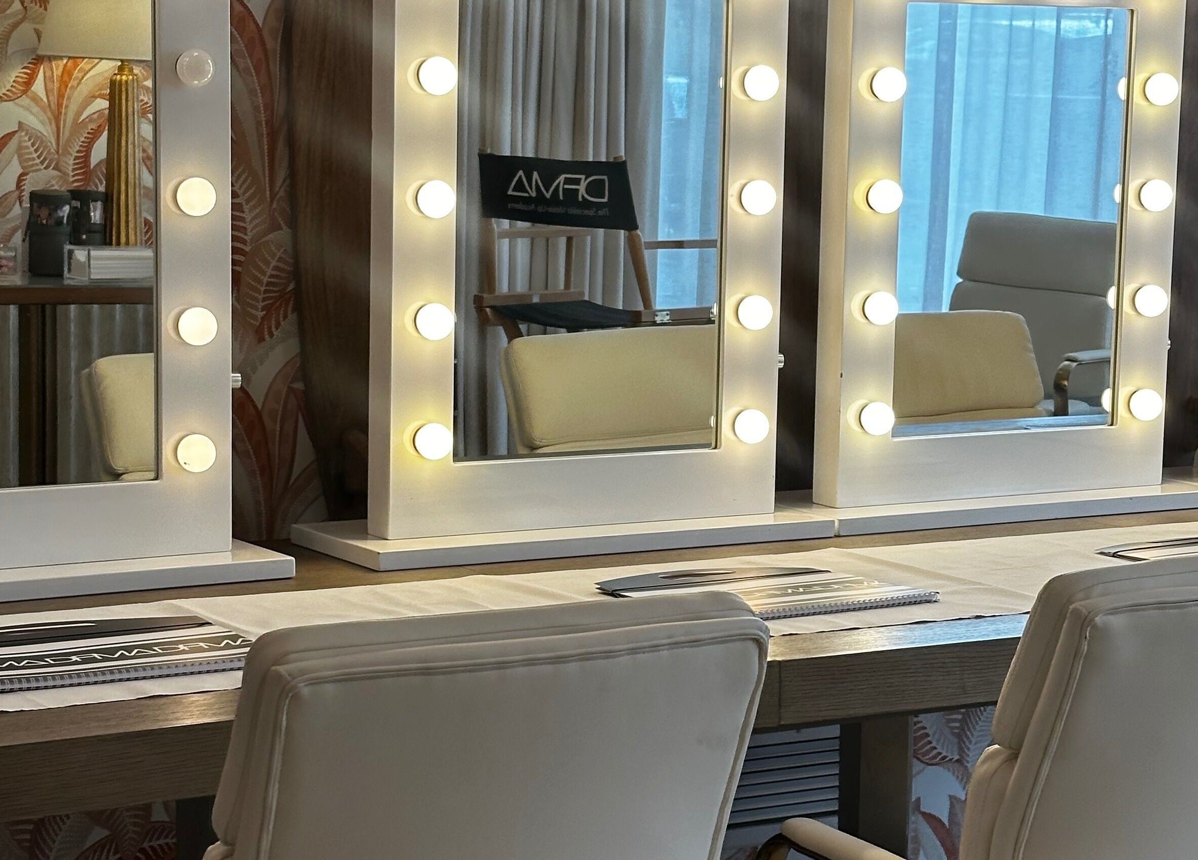 Makeup station with lit mirrors at Dfma Make Up & Hair Bar, Poole, England, GB, designed for professional styling.