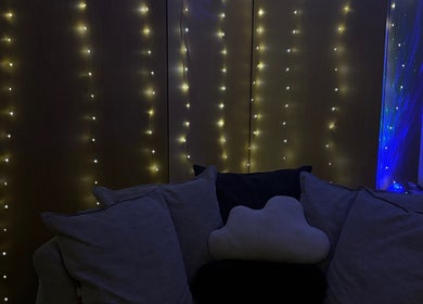 Warm fairy lights over a comfy sofa at AmyEBeauty, Suffolk, England, GB. Ideal for a relaxing experience.