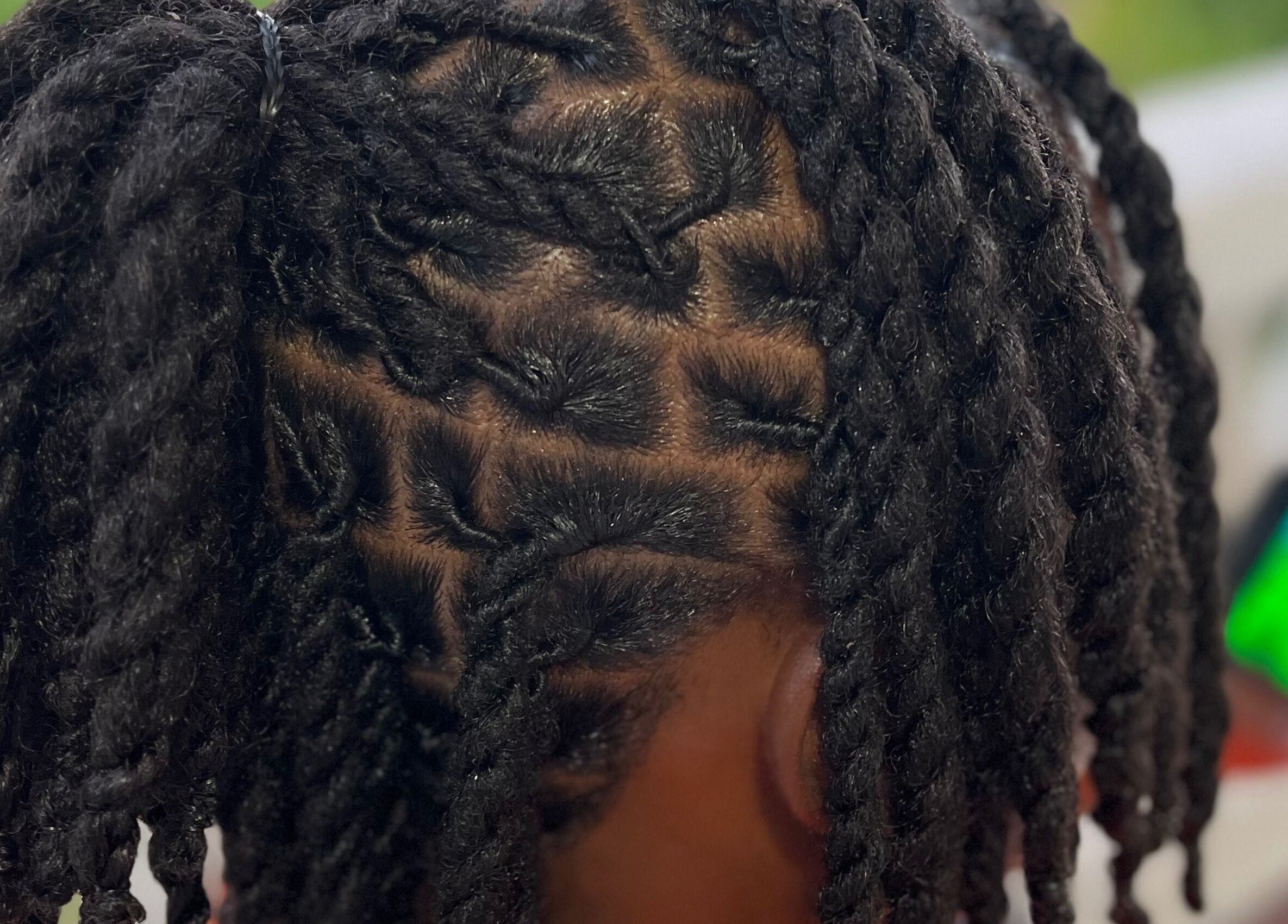 Intricate twist hairstyle at Locsdesire, Trinity, KN, showcasing expert braiding techniques.