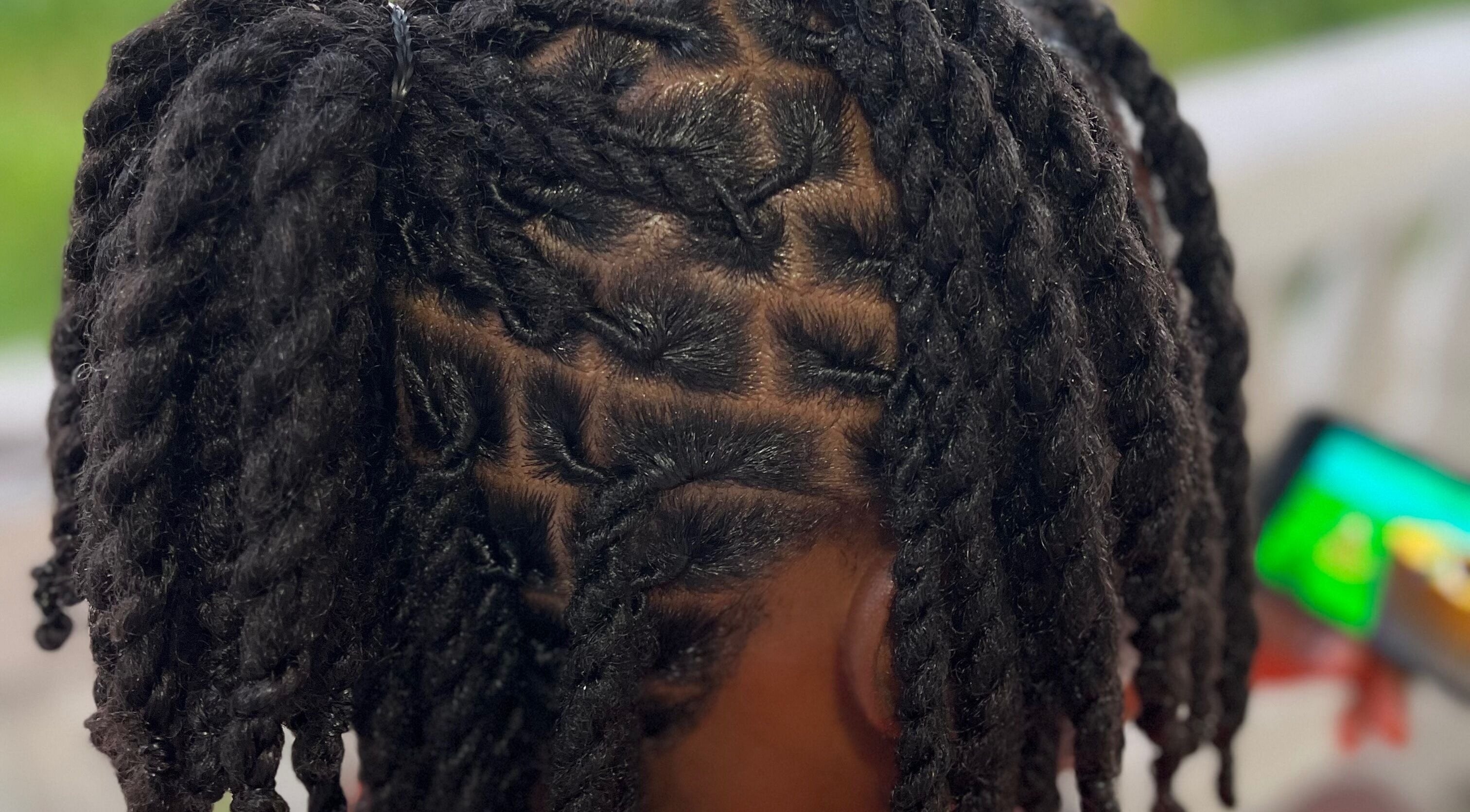Intricate twist hairstyle at Locsdesire, Trinity, KN, showcasing expert braiding techniques.