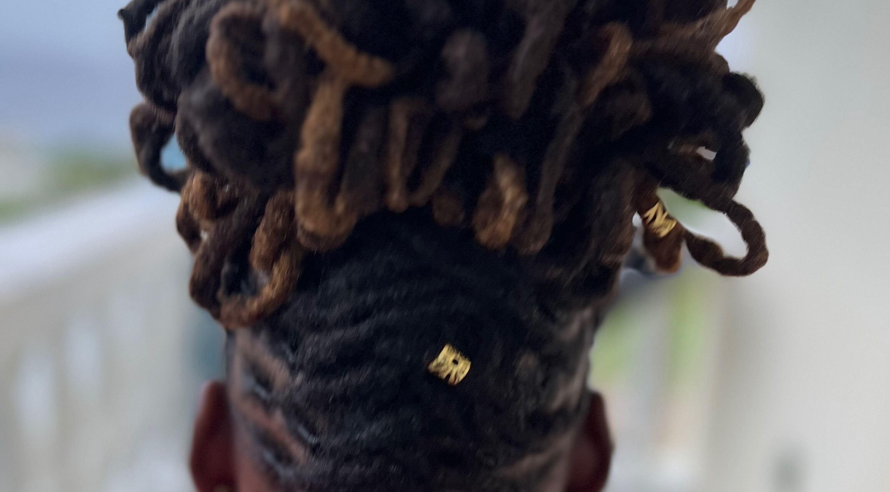 Close-up of styled locs with gold accents at Locsdesire, Trinity, KN.