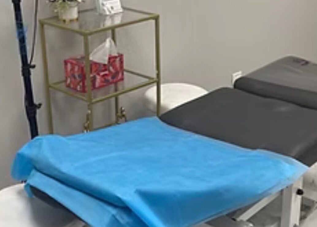Treatment room at EverlastInk Beauty, Inc., Copiague, New York, US, featuring a comfortable massage table.