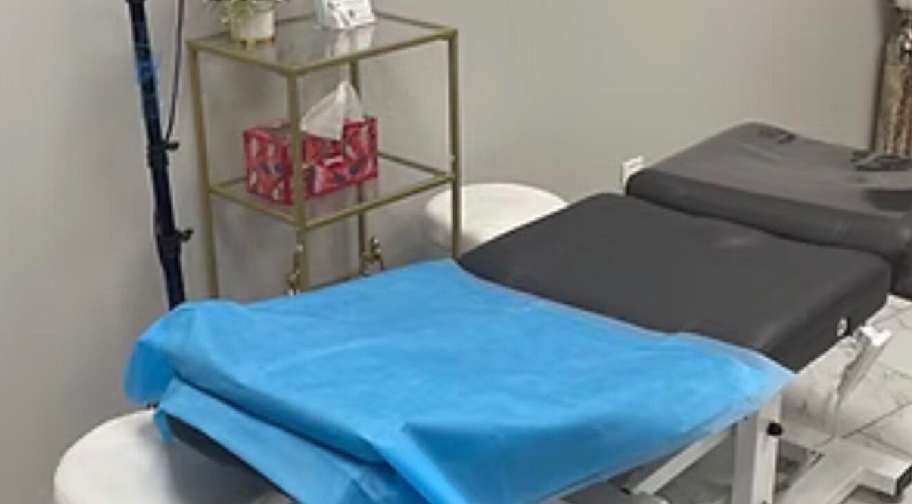 Treatment room at EverlastInk Beauty, Inc., Copiague, New York, US, featuring a comfortable massage table.
