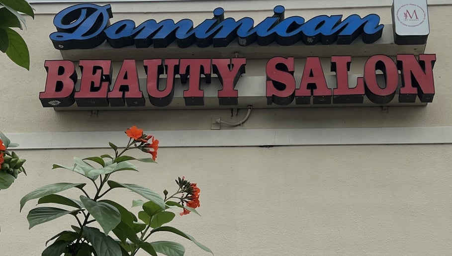 Signage of Dominican Salon - West Kendall with vibrant flowers in Miami, Florida, US.