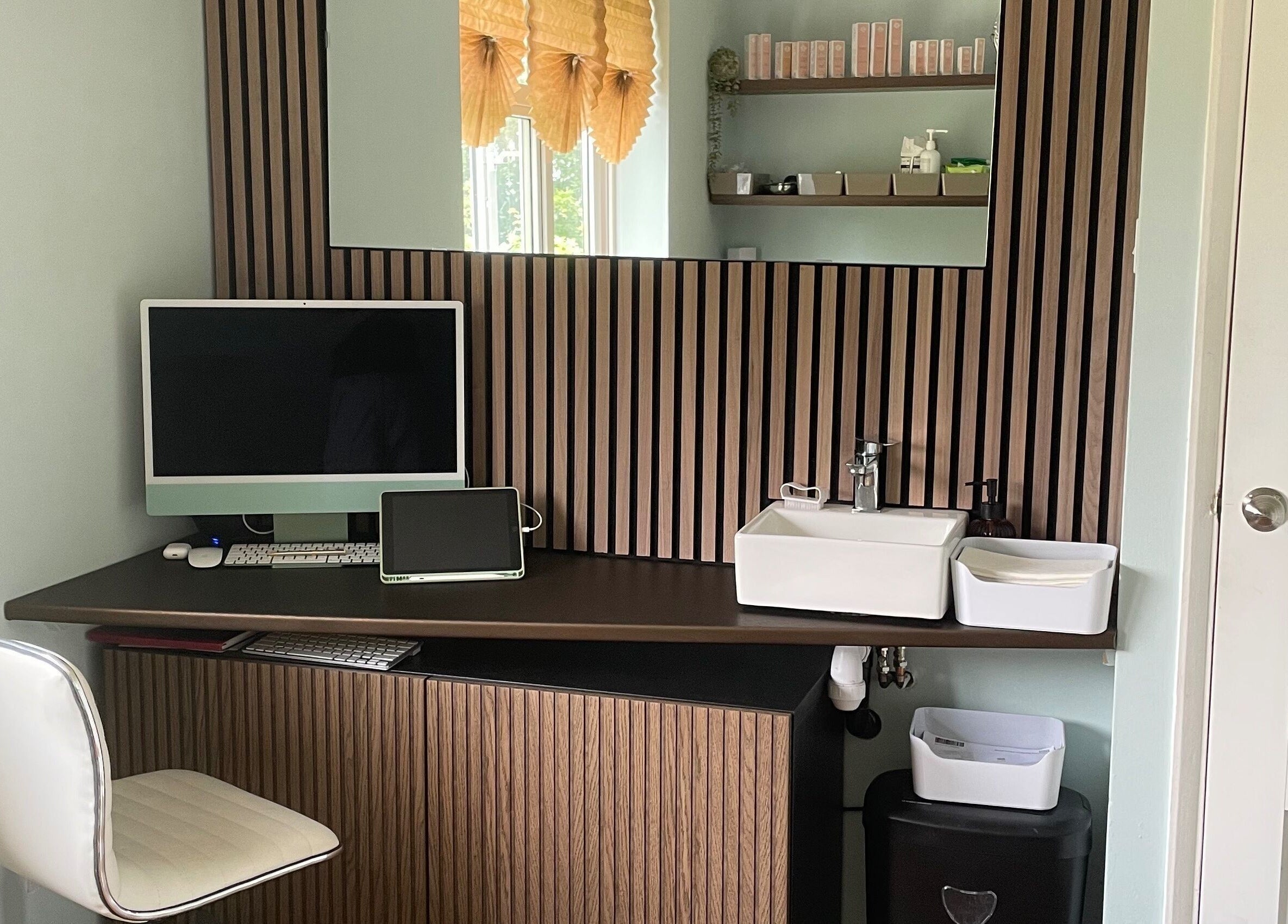 Sleek workspace at Oxley Aesthetics, Hemel Hempstead, England, GB with computer, sink, and decorative shelves.