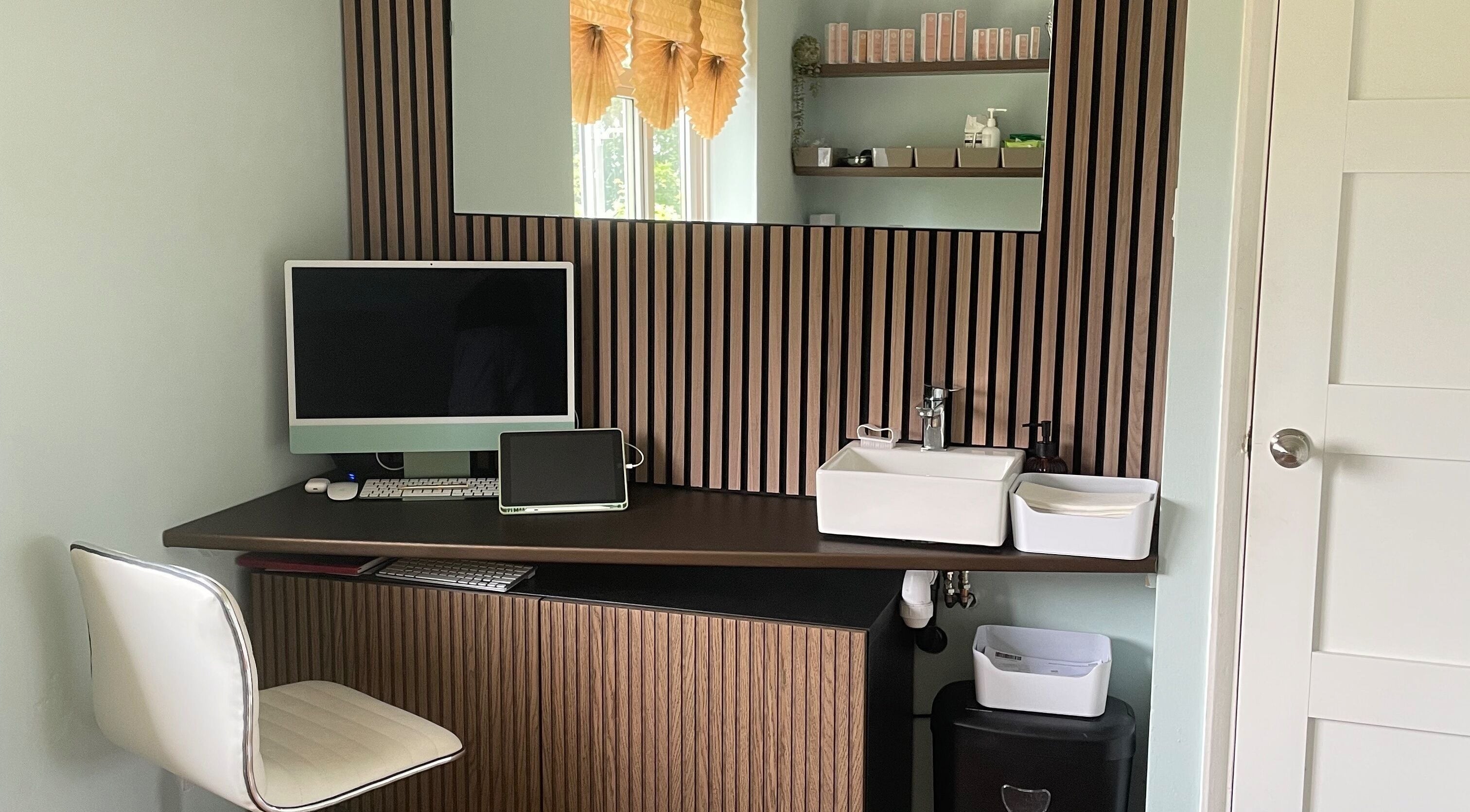 Sleek workspace at Oxley Aesthetics, Hemel Hempstead, England, GB with computer, sink, and decorative shelves.