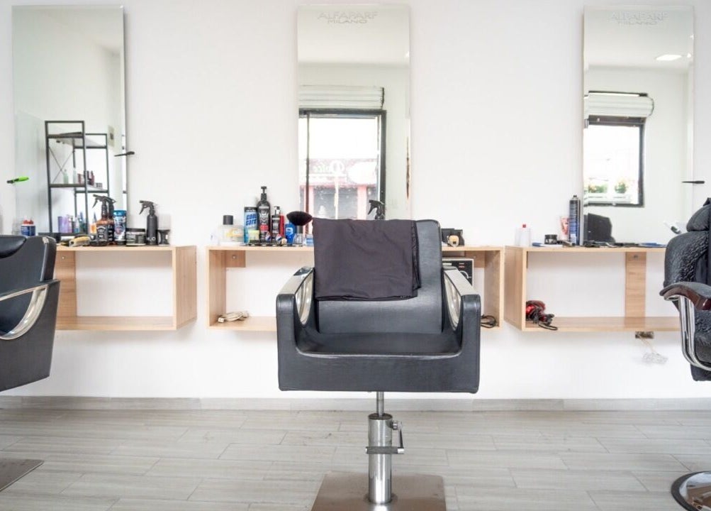 Interior moderno de Uio Color Peluqueria en Sheridan, Wyoming, US con sillas y espejos chic.