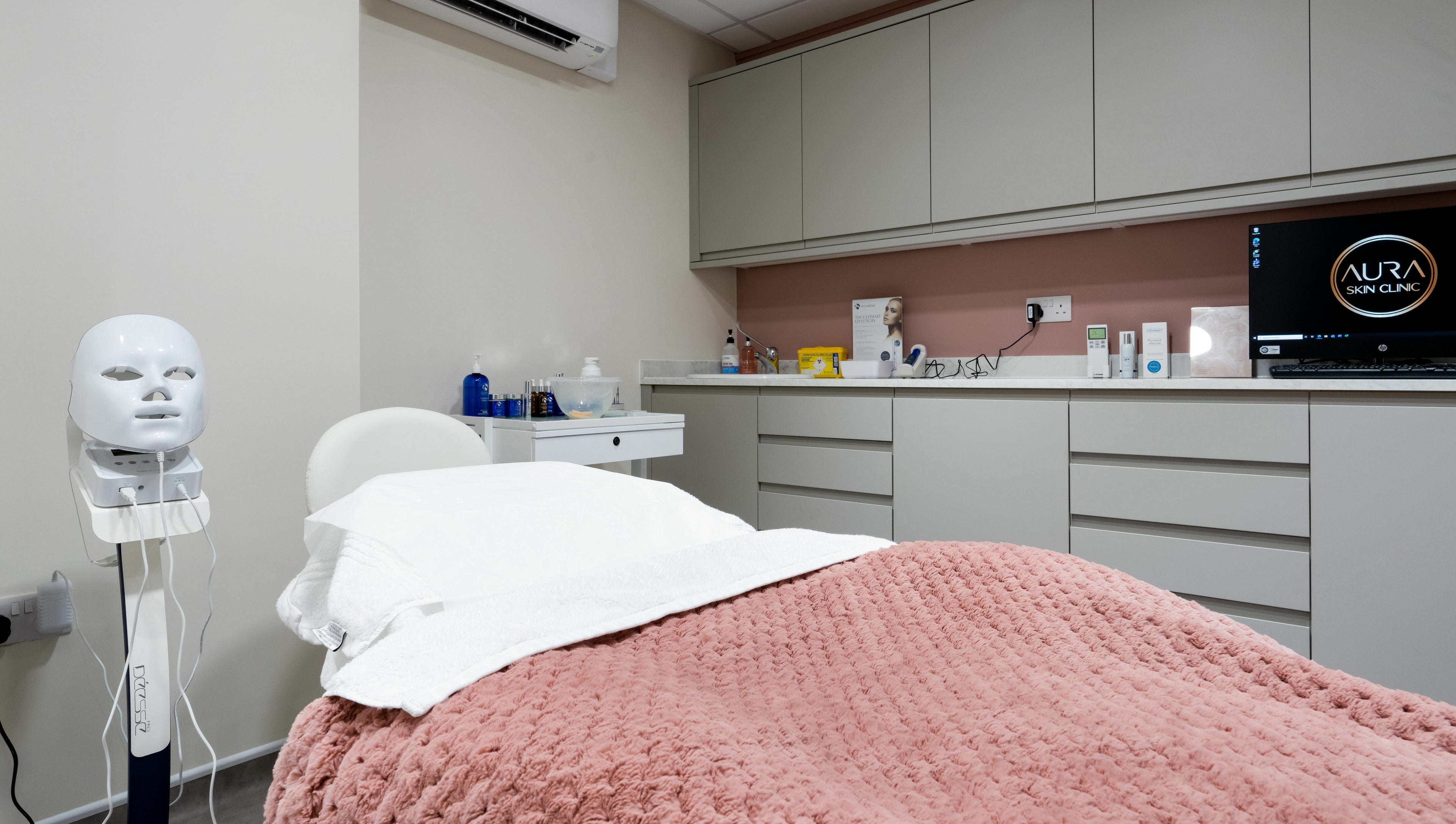 Relaxing treatment room at Aura Skin Clinic, Milton Keynes, England, GB, featuring a plush blanket and beauty equipment.