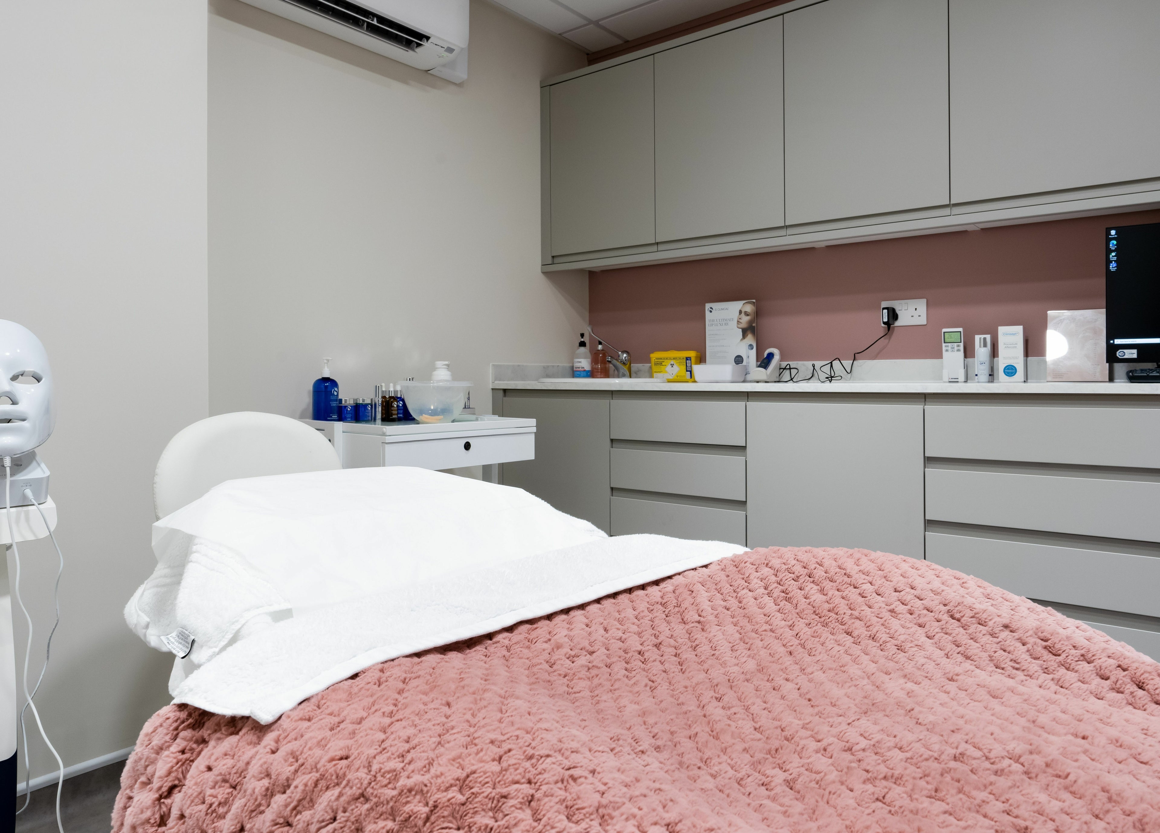 Relaxing treatment room at Aura Skin Clinic, Milton Keynes, England, GB, featuring a plush blanket and beauty equipment.