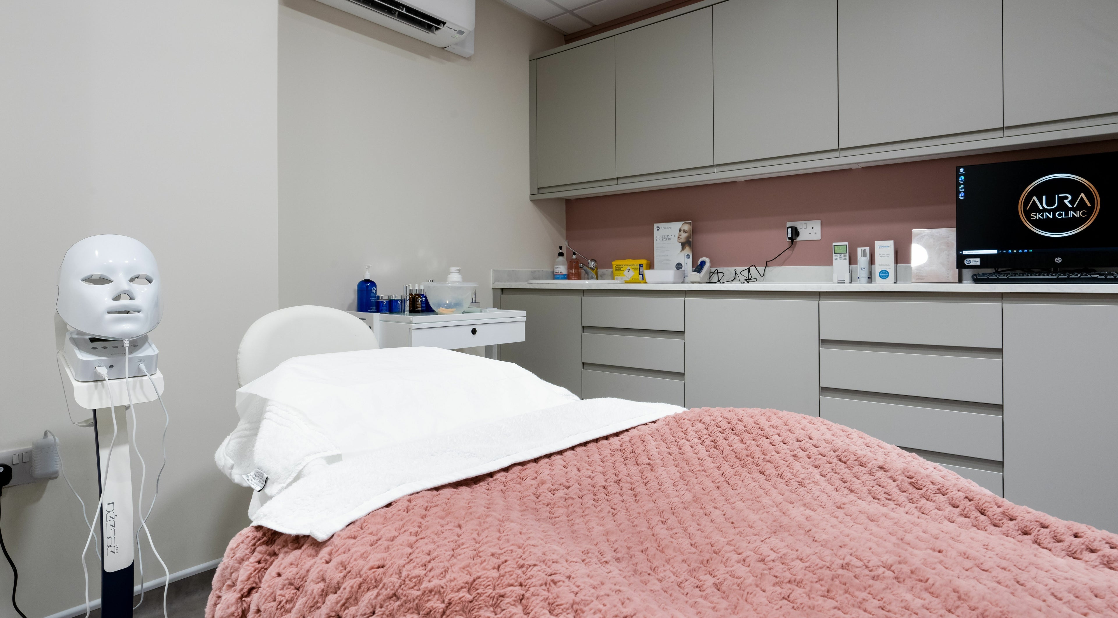 Relaxing treatment room at Aura Skin Clinic, Milton Keynes, England, GB, featuring a plush blanket and beauty equipment.