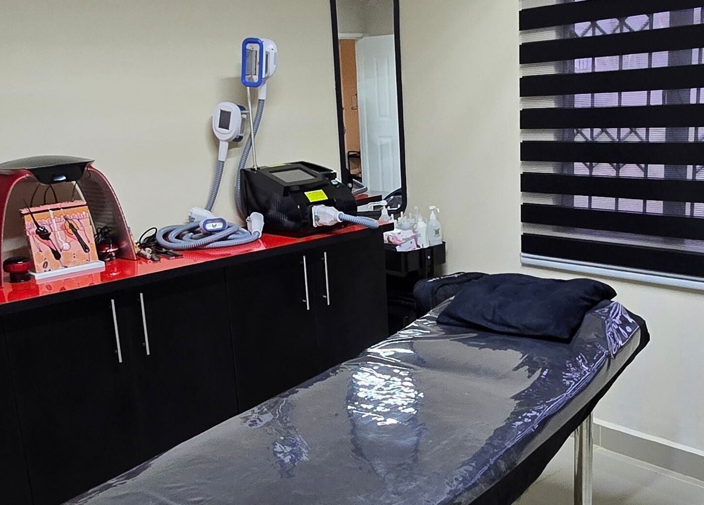 Sozo Laser Aesthetics treatment room in Phoenix, Kwazulu-natal, ZA with equipment and comfortable table.