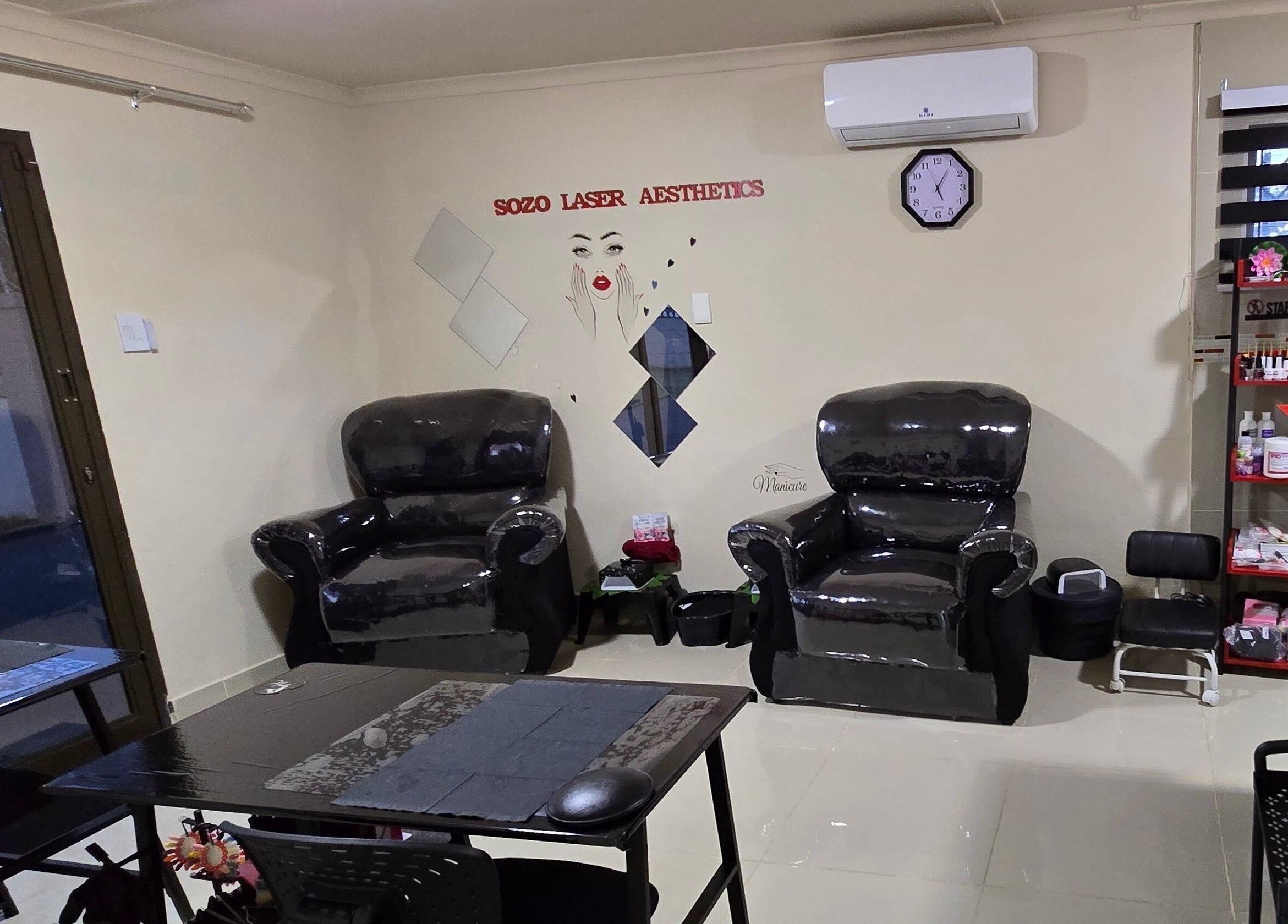 Cozy seating area at Sozo Laser Aesthetics in Phoenix, Kwazulu-natal, ZA with dark armchairs and elegant decor.