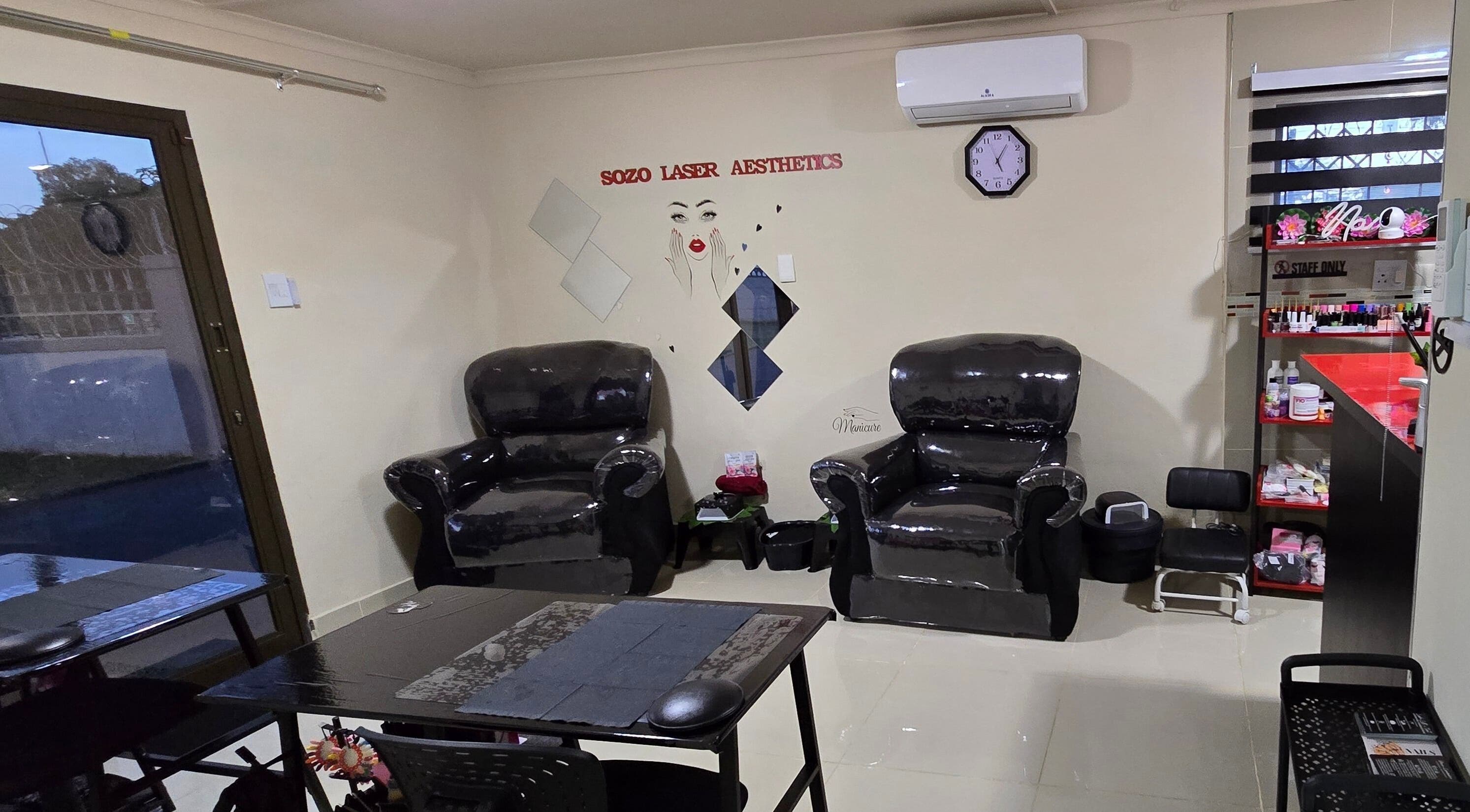 Cozy seating area at Sozo Laser Aesthetics in Phoenix, Kwazulu-natal, ZA with dark armchairs and elegant decor.