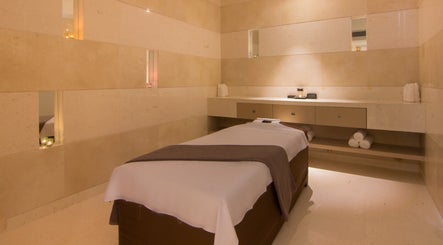 Tranquil massage room at The Spa at Sun and Moon Urban, Phnom Penh, Phnom Penh, KH, featuring a cozy ambiance.