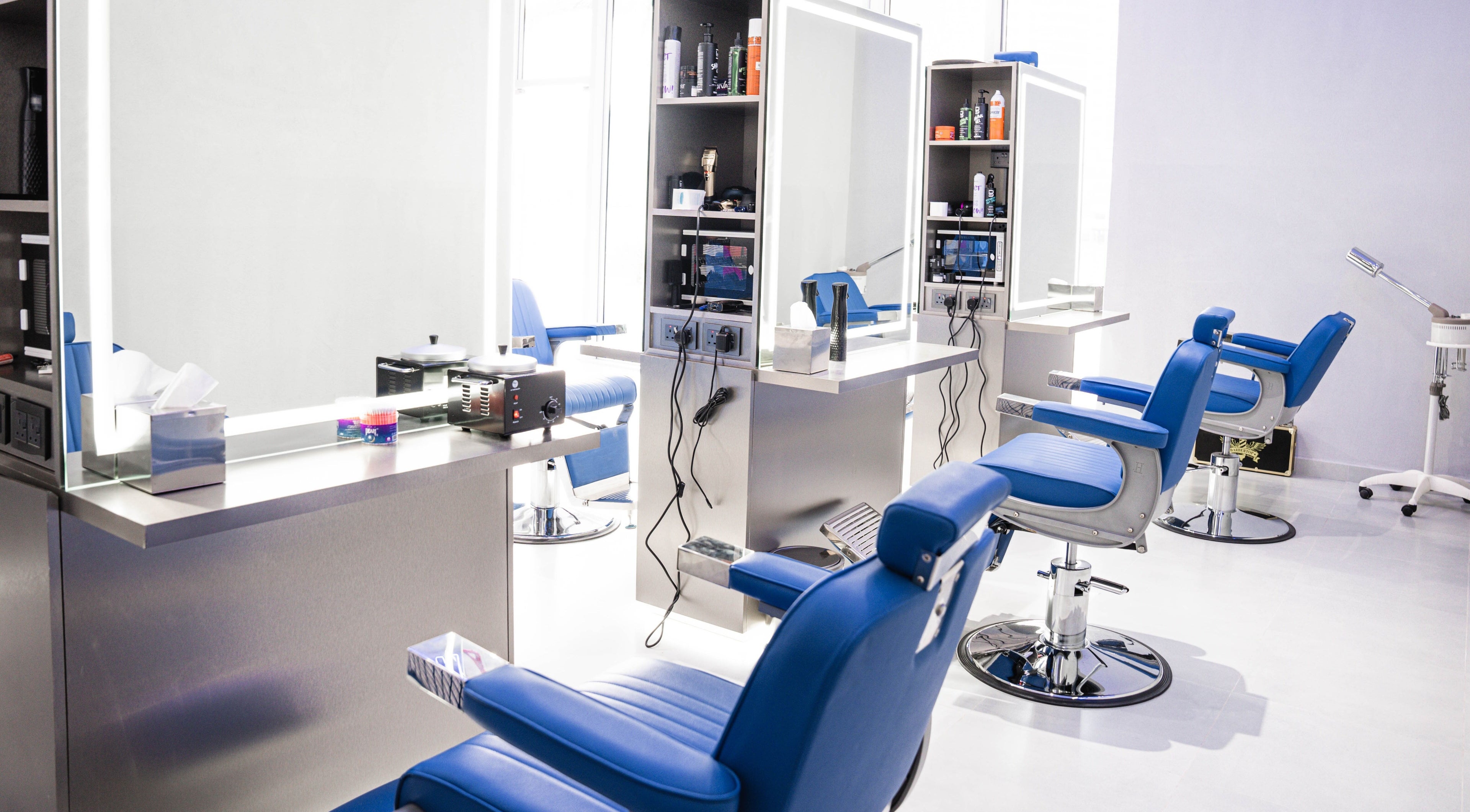 Chic interior of Back Alive Barbershop | Marina in دبي, دبي, AE with sleek barber chairs and mirrors.
