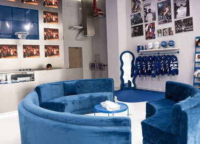 Modern lounge area at Back Alive Barbershop | Marina, featuring blue sofas and vibrant decor in دبي, دبي, AE.