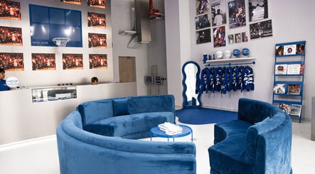 Modern lounge area at Back Alive Barbershop | Marina, featuring blue sofas and vibrant decor in دبي, دبي, AE.