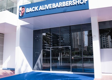 Entrance of Back Alive Barbershop | Marina in دبي, دبي, AE, reflecting a modern cityscape.