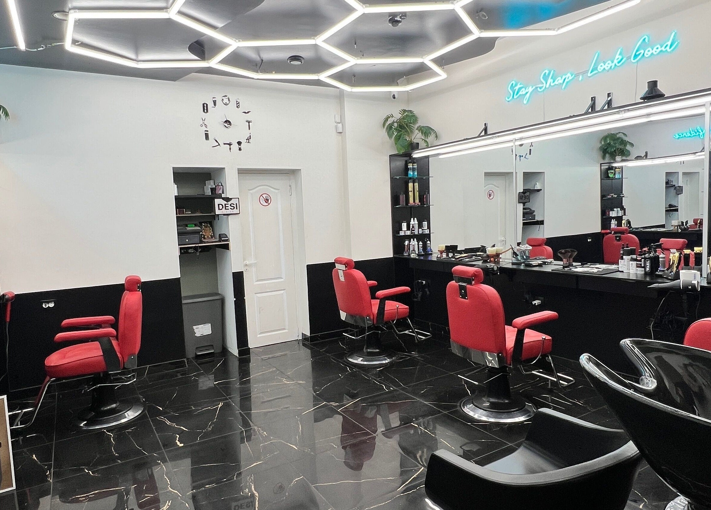 Modern salon interior at Desi (Aleksandra Caka), Rīga, LV with red chairs and sleek decor.