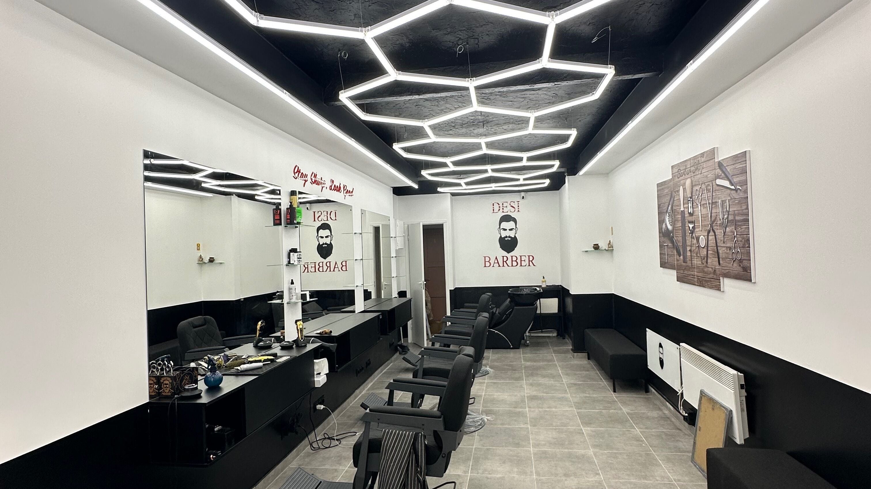 Modern barber shop at Desi (Brivibas Iela) in Rīga, LV with stylish hexagon lighting and sleek interior design.