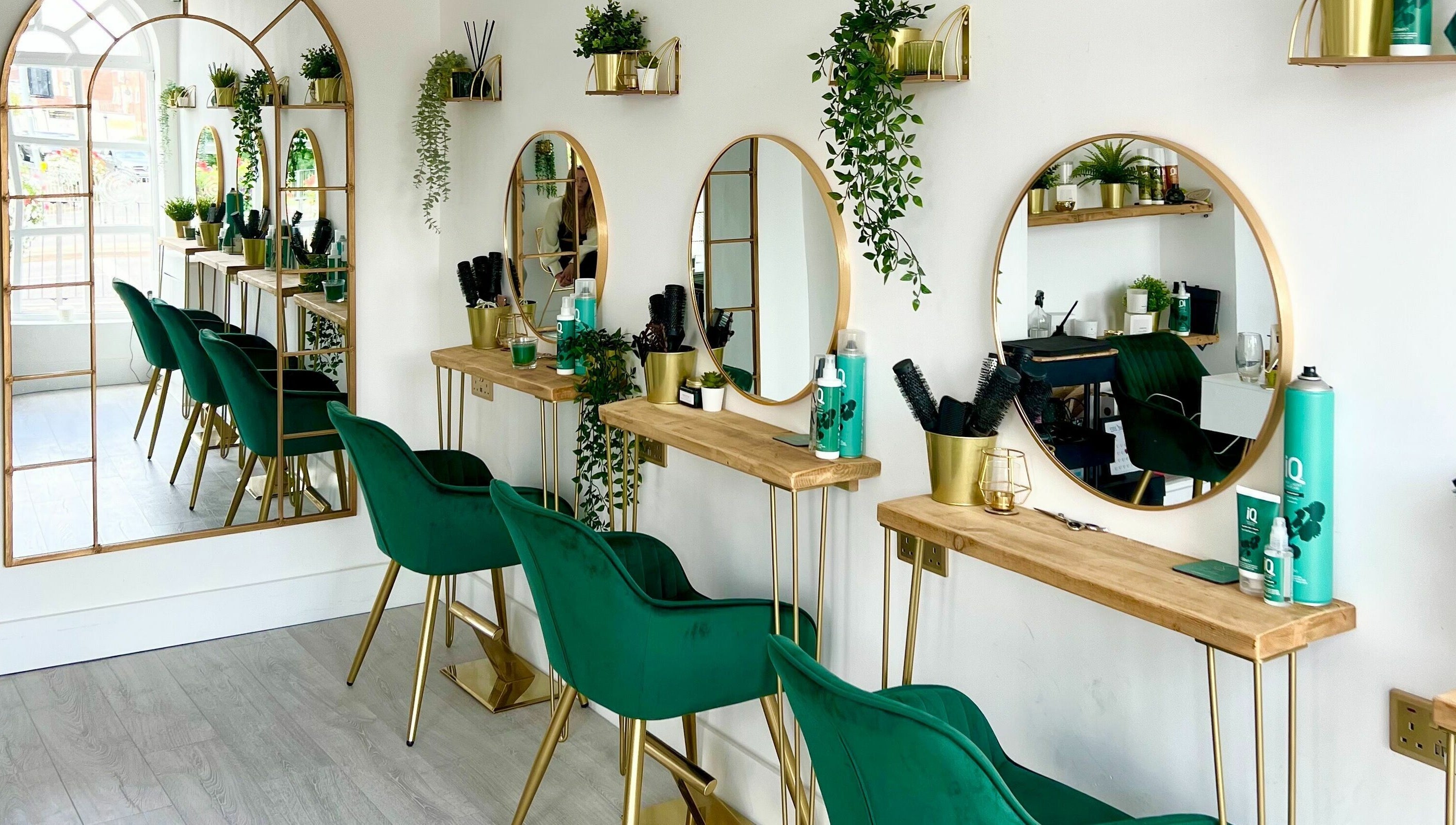Chic salon interior with green chairs and mirrors at Studio 66, Broxbourne, England, GB.