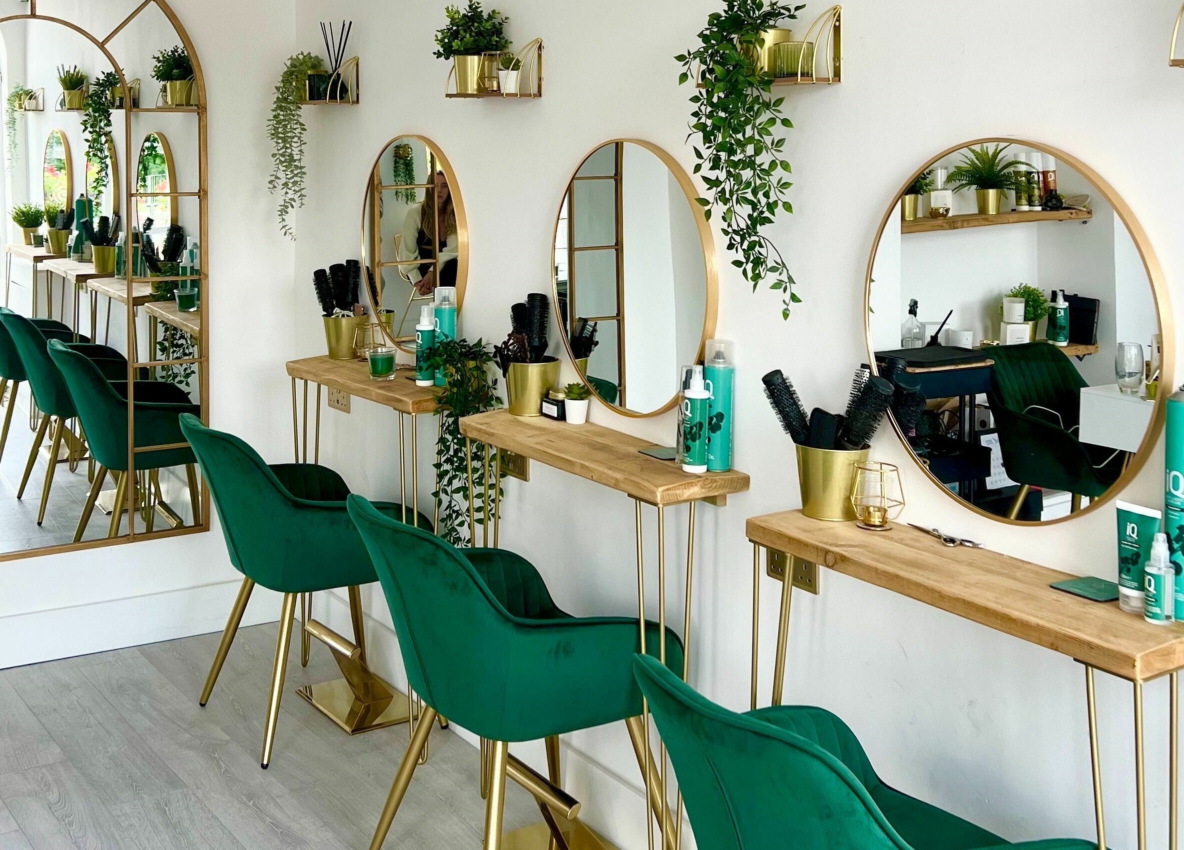 Chic salon interior with green chairs and mirrors at Studio 66, Broxbourne, England, GB.