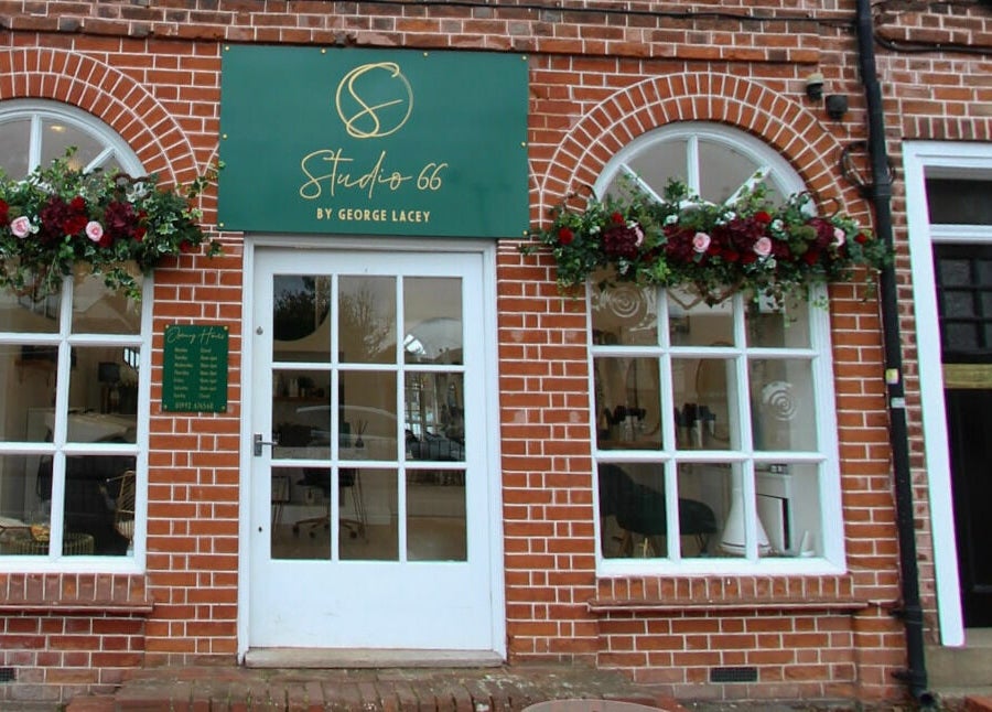 Front view of Studio 66, a stylish beauty venue in Broxbourne, England, GB with red brick and floral decor.
