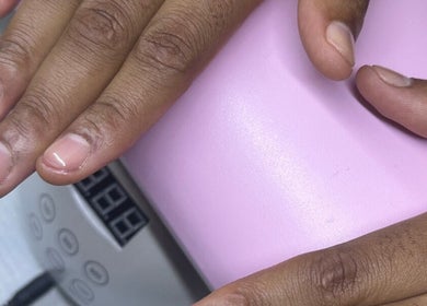 Client drying nails under UV lamp at Hunny's Clinique, Rustenburg, North West, ZA for a smooth finish.