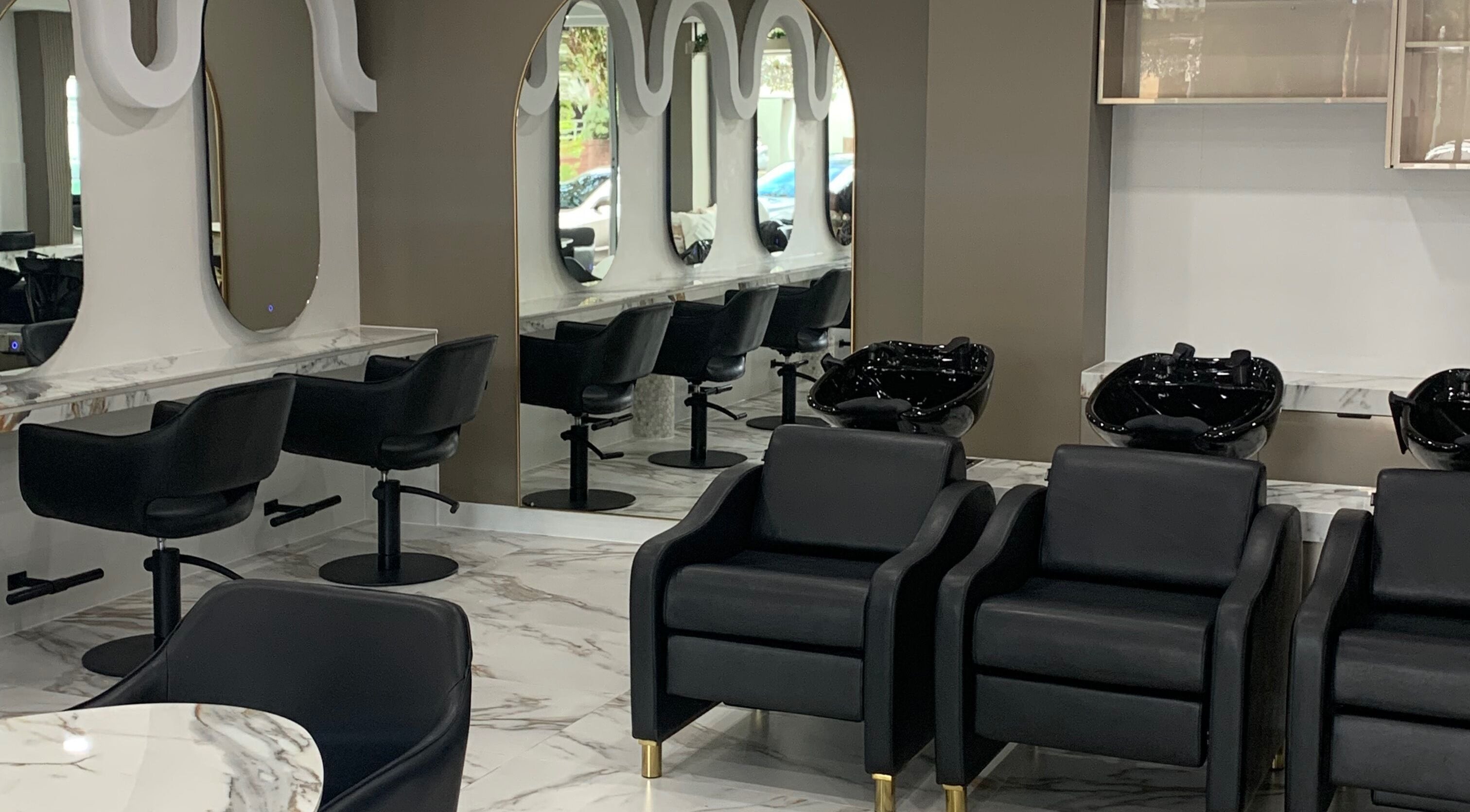 Modern salon interior at Infinitii Hair Port Melbourne, featuring sleek chairs and mirrors in Melbourne, Victoria, AU.