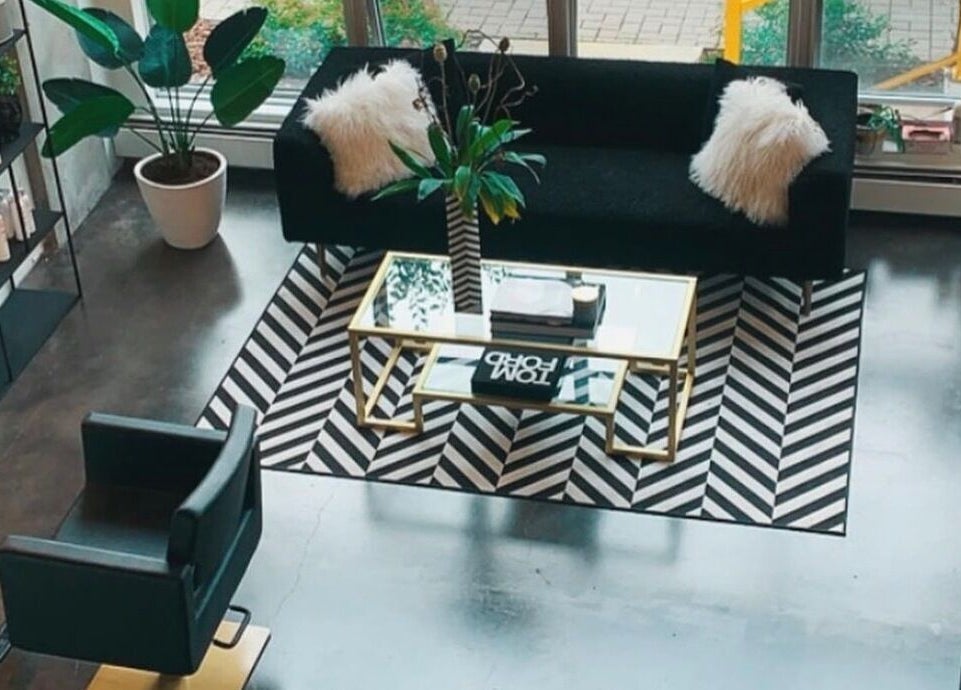 Stylish seating area at Crimson & Clovis, Calgary, Alberta, CA with plush sofa and sleek decor.