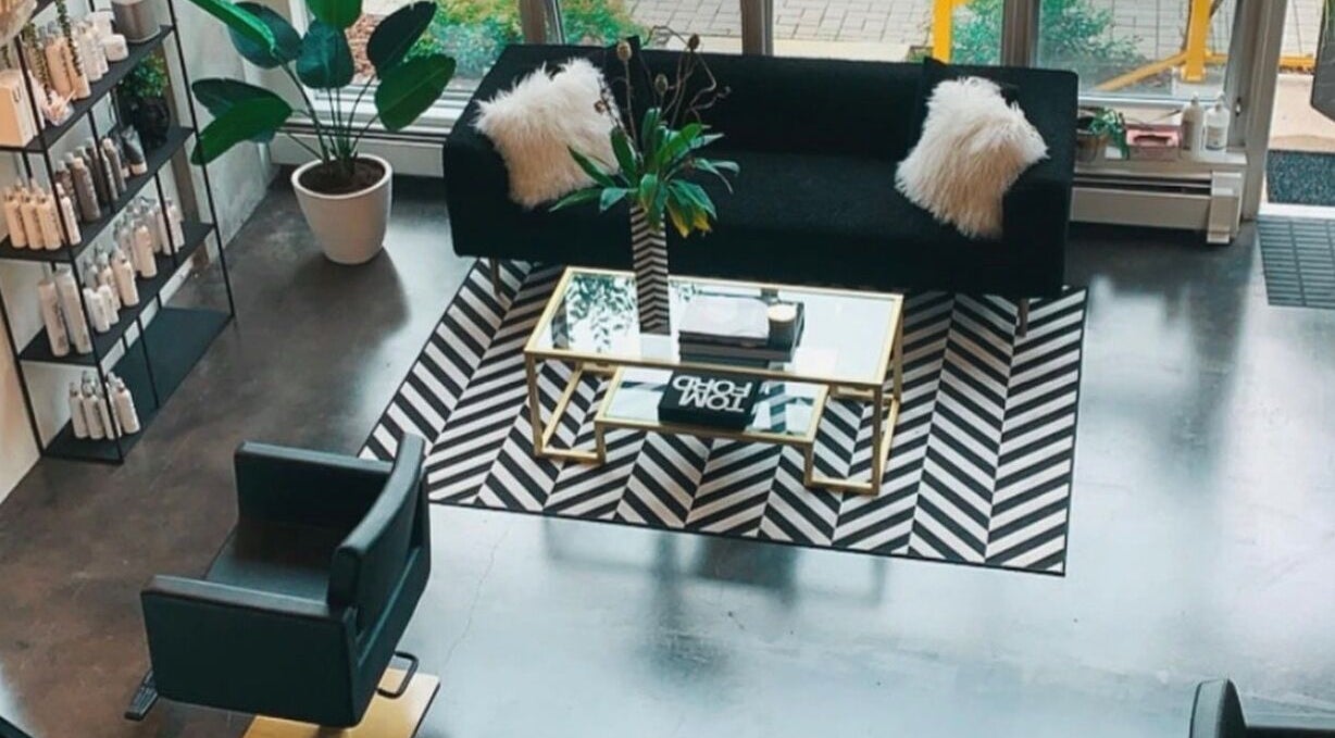 Stylish seating area at Crimson & Clovis, Calgary, Alberta, CA with plush sofa and sleek decor.