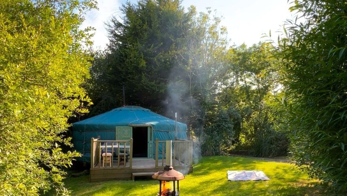 Cozy yurt at Wellness in the Wild, Newquay, England, GB, surrounded by lush greenery.