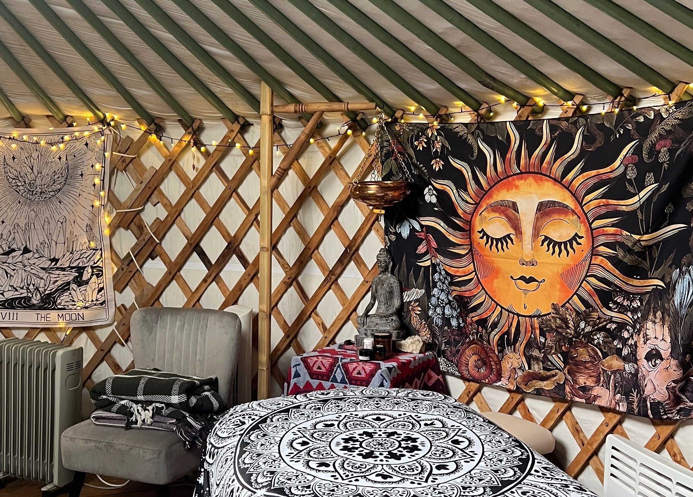 Cozy yurt interior at Wellness in the Wild, Newquay, England, GB with vibrant sun and moon tapestry.